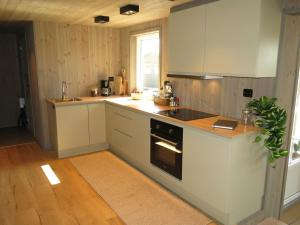 a kitchen with white cabinets and a stove top oven at Holiday Home Bjørkstue - SOW149 by Interhome in Fossdal