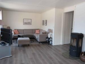 een woonkamer met een bank en een tv bij Holiday Home Furuholmen - FJS293 by Interhome in Lavik
