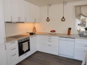 een keuken met witte kasten en een fornuis met oven bij Holiday Home Furuholmen - FJS293 by Interhome in Lavik