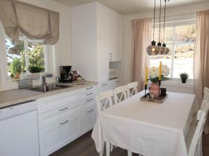 cocina blanca con mesa blanca y sillas en Holiday Home Furuholmen - FJS293 by Interhome, en Lavik