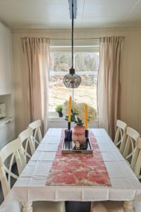 een eetkamer met een witte tafel en een raam bij Holiday Home Furuholmen - FJS293 by Interhome in Lavik