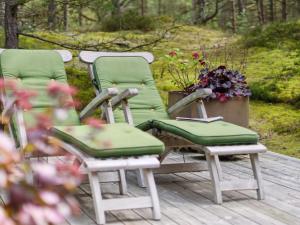 drie ligstoelen op een terras met bloemen bij Holiday Home Alita - 300m from the sea in Bornholm by Interhome in Vester Sømarken
