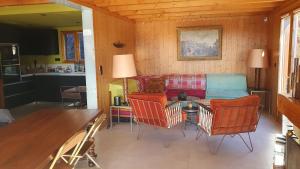 a living room with a couch and chairs and a table at Chalet Le Chant des Etoiles in Mende