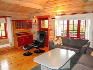 a living room with a couch and a table and chairs at Chalet Kakebu by Interhome in Gjerstad