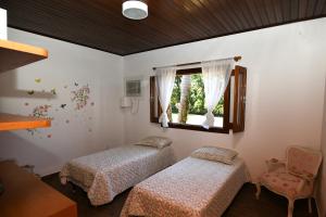 um quarto com 2 camas e uma janela em Sitio Agua Doce em Santa Branca