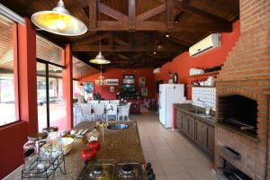 uma cozinha com paredes vermelhas e uma lareira de tijolos em Sitio Agua Doce em Santa Branca