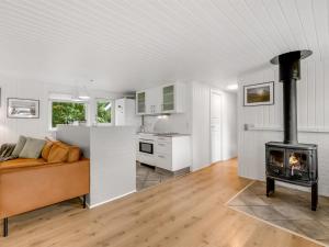 ein Wohnzimmer mit einem Sofa und einem Herd in der Unterkunft Holiday Home Waghn - all inclusive - 800m to the inlet by Interhome in Ulfborg