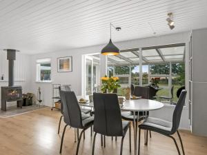 ein Esszimmer mit einem Tisch, Stühlen und einem Kamin in der Unterkunft Holiday Home Waghn - all inclusive - 800m to the inlet by Interhome in Ulfborg