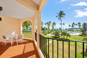 a balcony with a table and chairs and a view of the ocean at BEACH ACCESS + 3 Pools + OCEAN VIEWS - 2BR In Palmas - Sleeps 7 in Humacao