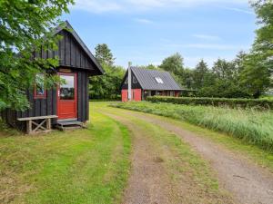 czarno-czerwona stodoła i droga gruntowa w obiekcie Holiday Home Thana - 8km from the sea in Bornholm by Interhome w mieście Gudhjem