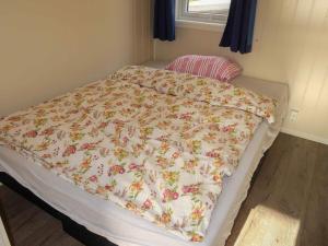 a bed with a floral comforter in a bedroom at Holiday Home Havbris - FJS152 by Interhome in Sørbø