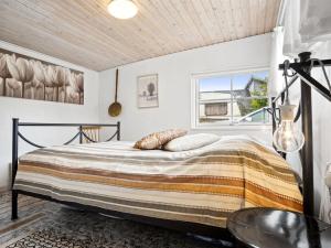 Schlafzimmer mit einem Bett und einem Fenster in der Unterkunft Holiday Home Aslak - 600m from the sea in Djursland and Mols by Interhome in Glesborg