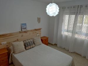 a bedroom with a bed and a pendant light at Piso en Playa de Gandía! in Gandía