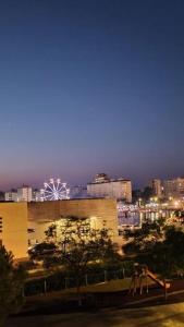 a city skyline at night with a ferris wheel in the distance at Piso en Playa de Gandía! in Gandía