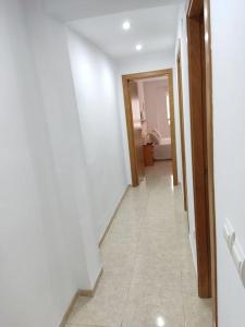 a hallway leading to a bathroom with a white wall at Piso en Playa de Gandía! in Gandía