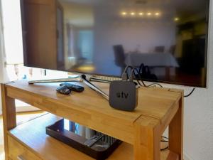 una mesa de madera con una TV encima. en Apartment Orya by Interhome, en Interlaken
