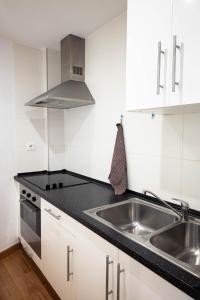 a white kitchen with a sink and a stove at Osario in Córdoba