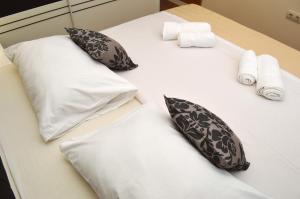 ein weißes Bett mit Kissen und Handtüchern darauf in der Unterkunft Apartment Ančica in Split