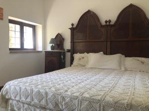 - une chambre avec un grand lit et une tête de lit en bois dans l'établissement Villa Nogarola - apartment with private pool and garden, à Costermano