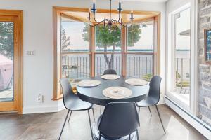 a dining room with a table and chairs and windows at Riverside Retreat in Brockville