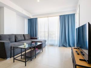 ein Wohnzimmer mit Sofa und Fernseher in der Unterkunft Apartment Gran Canet by Interhome in Canet d'en Berenguer