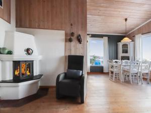 sala de estar con chimenea, mesa y sillas en Holiday Home Havbu - FJS166 by Interhome, en Korssund