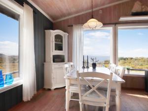 comedor con mesa, sillas y ventanas en Holiday Home Havbu - FJS166 by Interhome, en Korssund