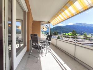 balkon ze stołem i krzesłami oraz widokiem w obiekcie Apartment Regina by Interhome w Davos