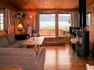 - un salon avec un canapé et une grande fenêtre dans l'établissement Chalet Trefall - FJH520 by Interhome, à Gausvik