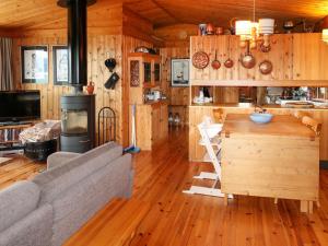 a living room with a couch and a kitchen with wooden walls at Chalet Trefall - FJH520 by Interhome in Gausvik