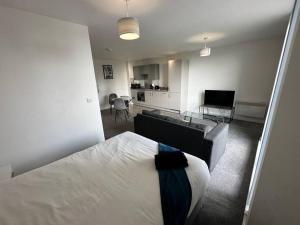 a bedroom with a bed and a living room at Fab, Spacious Studio+Balcony MCR in Manchester