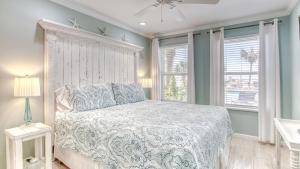 德斯坦Poolside Villas 106 - Updated beachfront condo on Holiday Isle in Destin的一间卧室配有一张蓝色墙壁和窗户的床