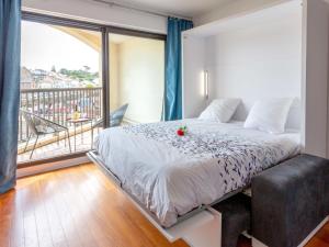 een slaapkamer met een groot bed en een balkon bij Apartment Le Continental by Interhome in Pornic