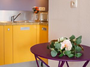 een paarse tafel met een boeket bloemen erop bij Apartment Le Continental by Interhome in Pornic +20 foto's