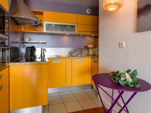 een keuken met gele kasten en een paarse tafel bij Apartment Le Continental by Interhome in Pornic