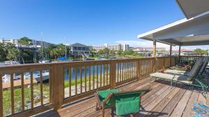 a deck with chairs and a table and a bench at The Back Porch - Is a relaxing 4 bedroom 3 bathroom House on Holiday Isle in Destin