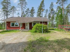 ein kleines rotes Haus mit einem Tor im Wald in der Unterkunft Holiday Home Malmi by Interhome in Jyrkkä
