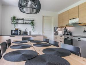 eine Küche mit einem großen Holztisch mit Stühlen in der Unterkunft Holiday Home Malmi by Interhome in Jyrkkä
