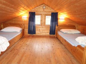 a room with two beds in a log cabin at Chalet Hagehytta - FJS047 by Interhome in Utvik