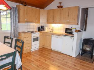 una cocina con electrodomésticos blancos y armarios de madera en Chalet Hagehytta - FJS047 by Interhome, en Utvik