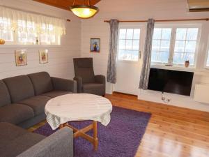 Chalet Hagehytta - FJS047 by Interhome في Utvik: غرفة معيشة مع أريكة وطاولة وتلفزيون