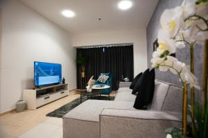 a living room with a couch and a tv at Elite Residence 2BR Luxurious Palm View in Dubai Marina in Dubai