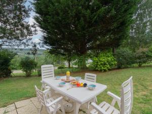 a white table and chairs in a yard at Holiday Home La Cour du Moulin-6 by Interhome in Houlgate