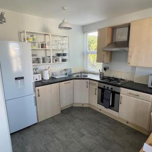 a kitchen with a white refrigerator and a sink at Swanage Bay Coastal Apartment in Swanage