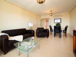 ein Wohnzimmer mit einem Sofa, einem Tisch und Stühlen in der Unterkunft Apartment Sabater 17 by Interhome in Calpe