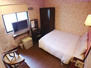 a hotel room with a bed and a television at Fu Chia Hotel in Keelung