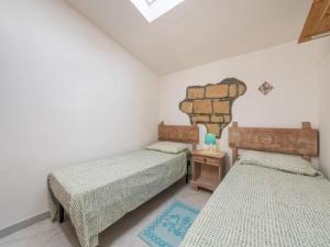 een slaapkamer met 2 bedden en een tafel met een lamp bij Apartment L'appartamento nel Corso by Interhome in Carloforte