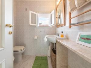 une salle de bain avec un lavabo et des toilettes et une fenêtre dans l'établissement Apartment L'appartamento nel Corso by Interhome, à Carloforte