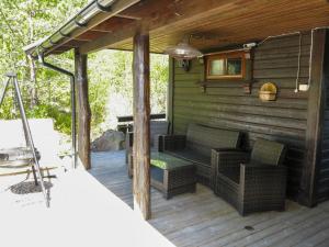een patio met rieten meubels op een houten terras bij Chalet Mariabu - SOW142 by Interhome in Fossdal