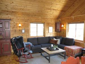 een woonkamer met een bank en een tafel bij Chalet Mariabu - SOW142 by Interhome in Fossdal